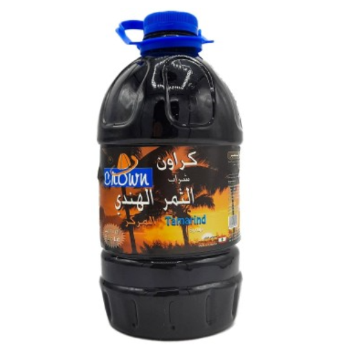 A plastic bottle of Crown Tamarind syrup with a blue cap, labeled in English and Arabic, against a white background.