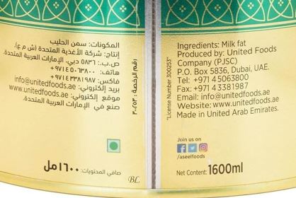 A close-up of a printed package label with Arabic text on a pale yellow background and green decorative borders at the top. Visible text includes 'Ingredients: Milk fat' and 'Produced by: United Foods Company (PJSC)'.
