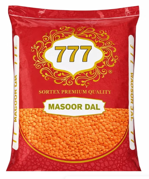A red bag of 777 Masoor Dal (red lentils) on a plain white background. The packaging features a large gold and white 777 logo, 'SORTEX PREMIUM QUALITY' text, and a clear window at the bottom showing the orange-red lentils inside.