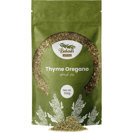 A 500g stand-up pouch of Baladi Thyme Oregano in olive green packaging, with a small pile of the dried herb visible at the bottom center against a plain white background.
