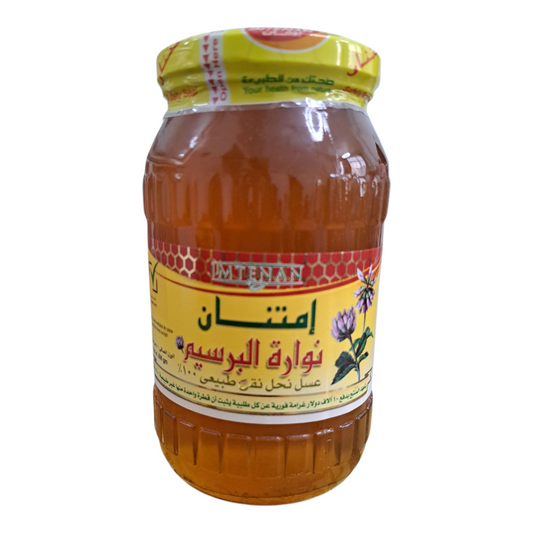 Jar of honey with a yellow label on a white background